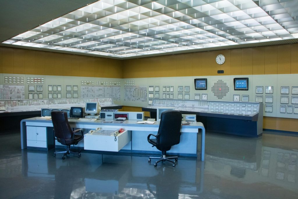 una sala de control con un escritorio y dos sillas