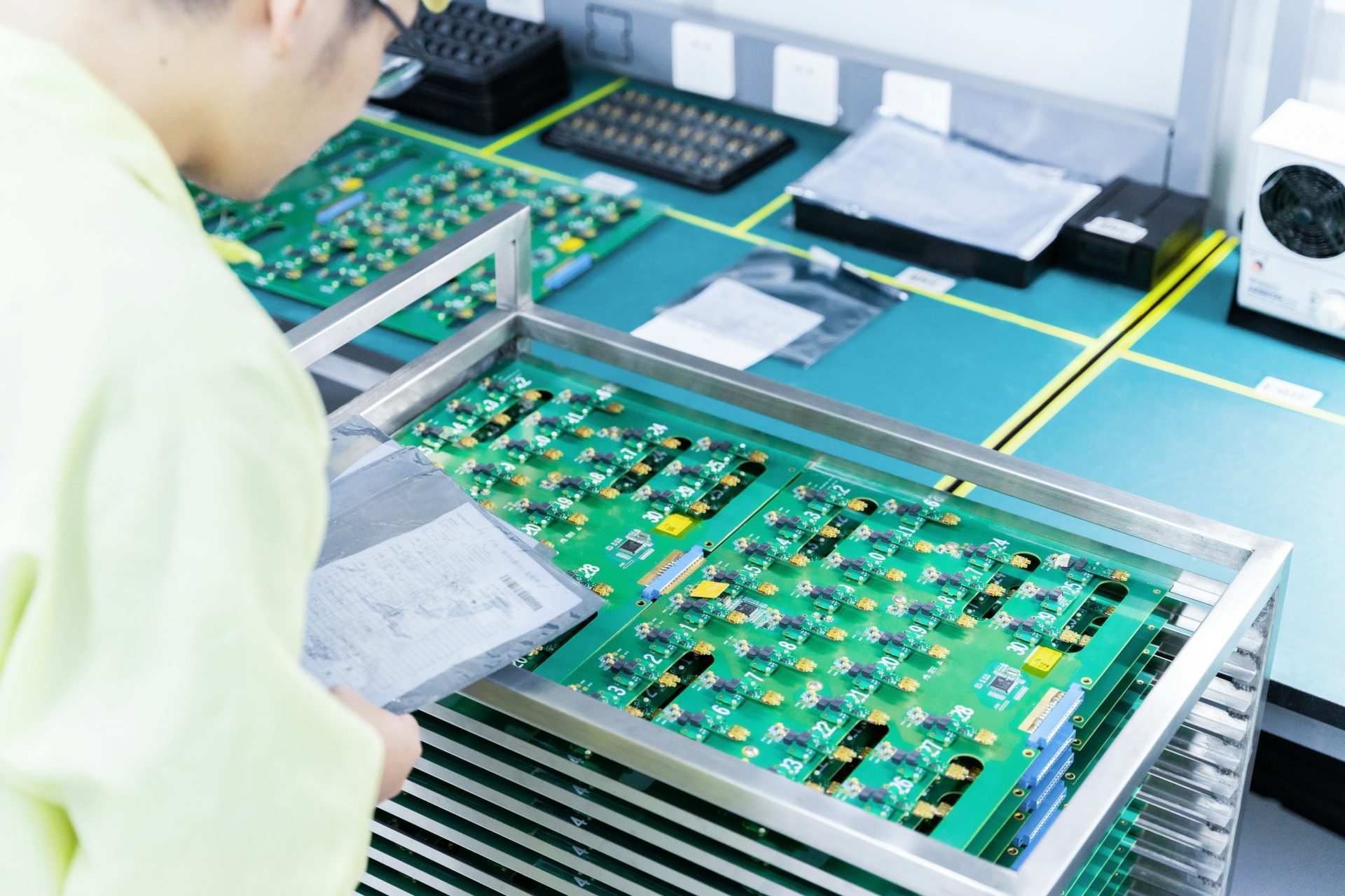 Un hombre trabajando con componentes electrónicos en una fábrica.